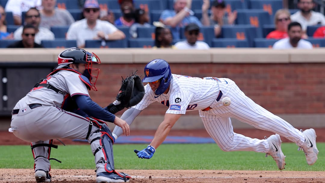 Jul 28, 2024; New York City, New York, USA; Atlanta Braves catcher Travis d'Arnaud (16) and New York Mets center fielder Tyrone Taylor (15)