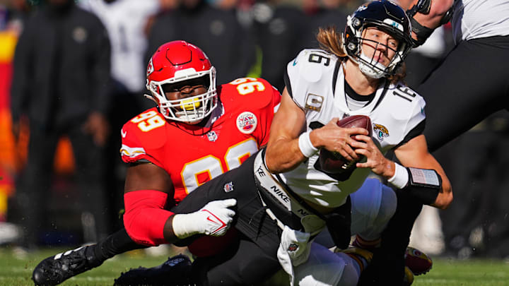 Jacksonville Jaguars quarterback Trevor Lawrence (16) is tackled by Kansas City Chiefs defensive tackle Khalen Saunders (99) during the first half at GEHA Field at Arrowhead Stadium.