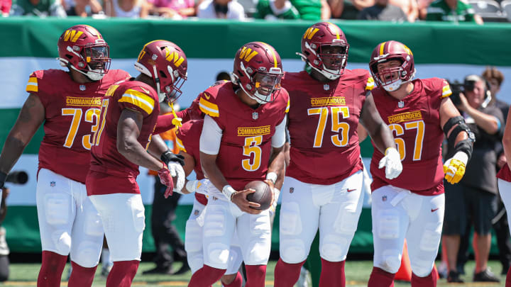 Aug 10, 2024; East Rutherford, New Jersey, USA; Washington Commanders quarterback Jayden Daniels (5) celebrates his touchdown with teammates during the first quarter against the New York Jets at MetLife Stadium. Mandatory Credit: Vincent Carchietta-USA TODAY Sports