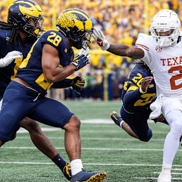 Texas wide receiver Matthew Golden (2) is stopped by Michigan defensive back Jyaire Hill (20), defensive back Quinten Johnson (28) during the first half at Michigan Stadium in Ann Arbor on Saturday, September 7, 2024.