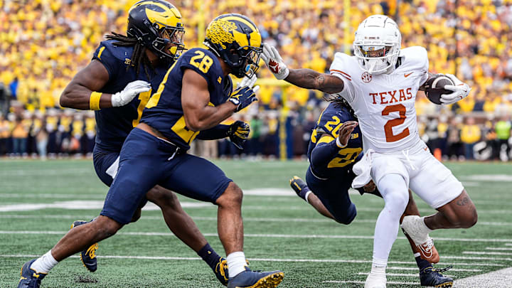 Texas wide receiver Matthew Golden (2) is stopped by Michigan defensive back Jyaire Hill (20), defensive back Quinten Johnson (28) during the first half at Michigan Stadium in Ann Arbor on Saturday, September 7, 2024.