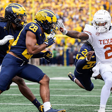 Texas wide receiver Matthew Golden (2) is stopped by Michigan defensive back Jyaire Hill (20), defensive back Quinten Johnson (28) during the first half at Michigan Stadium in Ann Arbor on Saturday, September 7, 2024.