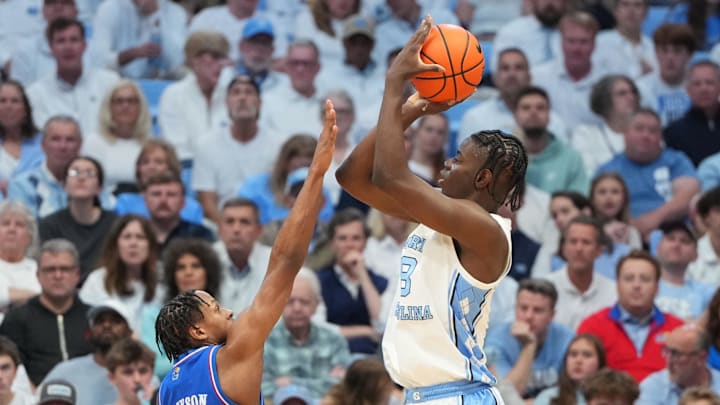 Nov 7, 2025; Chapel Hill, North Carolina, USA;  North Carolina Tar Heels forward Caleb Wilson (8) shoots as Kansas Jayhawks guard Elmarko Jackson (13) defends in the first half at Dean E. Smith Center. Mandatory Credit: Bob Donnan-Imagn Images