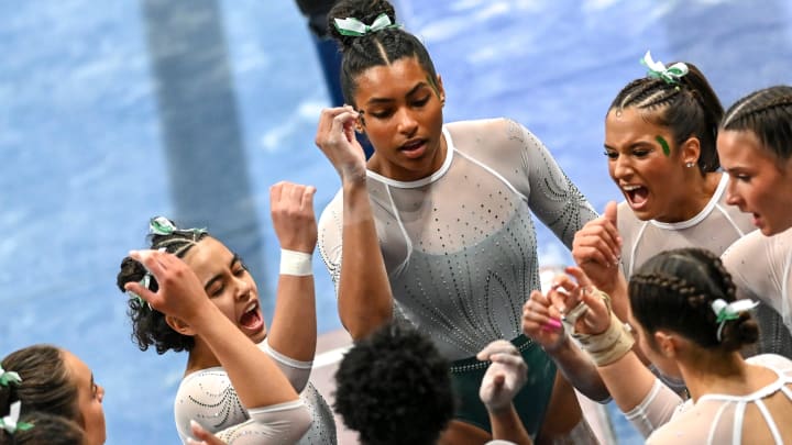 Michigan State huddles up before competing in the beam event on Friday, Feb. 9, 2024, during the