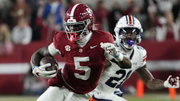 Nov 30, 2024; Tuscaloosa, Alabama, USA;  Alabama Crimson Tide wide receiver Germie Bernard (5) runs after making a catch against Auburn Tigers safety Caleb Wooden (21) during the second half at Bryant-Denny Stadium. Alabama won 28-14. Mandatory Credit: Gary Cosby Jr.-Imagn Images