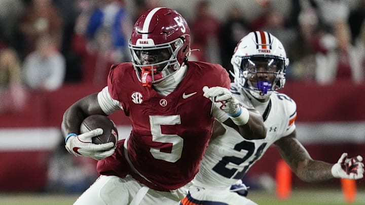 Nov 30, 2024; Tuscaloosa, Alabama, USA; Alabama Crimson Tide wide receiver Germie Bernard (5) runs after making a catch against Auburn Tigers safety Caleb Wooden (21) during the second half at Bryant-Denny Stadium. Alabama won 28-14. Mandatory Credit: Gary Cosby Jr.-Imagn Images Nov 30, 2024; Tuscaloosa, Alabama, USA; Alabama Crimson Tide wide receiver Germie Bernard (5) runs after making a catch against Auburn Tigers safety Caleb Wooden (21) during the second half at Bryant-Denny Stadium. Alabama won 28-14. Mandatory Credit: Gary Cosby Jr.-Imagn Images
