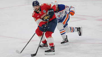 Jun 12, 2025; Sunrise, Florida, USA; Florida Panthers forward Sam Reinhart (13) passes the puck against Edmonton Oilers center Connor McDavid (97) during the third period in game four of the 2025 Stanley Cup Final at Amerant Bank Arena. Mandatory Credit: Sam Navarro-Imagn Images