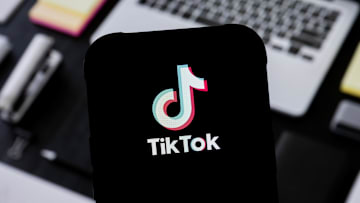 In this photo illustration, a TikTok logo seen displayed on...