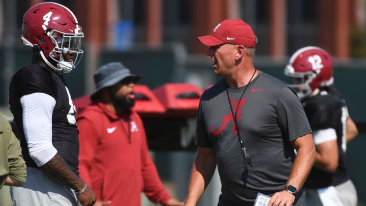 Alabama quarterback Jalen Milroe (4) listens to directions from Alabama head coach Kalen DeBoer.