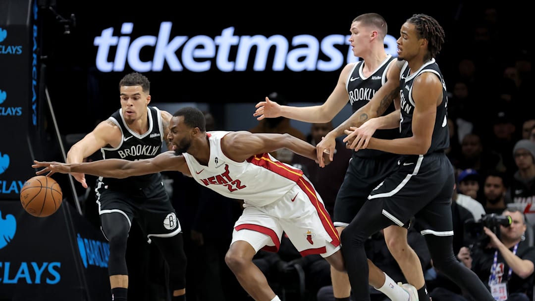 Dec 18, 2025; Brooklyn, New York, USA; Miami Heat forward Andrew Wiggins (22) fights for the ball against Brooklyn Nets forward Michael Porter Jr. (17) and guard Egor Demin (8) and center Nic Claxton (33) during the first quarter at Barclays Center. Mandatory Credit: Brad Penner-Imagn Images
