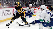 Nov 27, 2024; Pittsburgh, Pennsylvania, USA;  Pittsburgh Penguins defenseman Marcus Pettersson (28) moves the puck against Vancouver Canucks center Elias Pettersson (40) and Vancouver Canucks left wing Jake DeBrusk (74) during the second period at PPG Paints Arena. Mandatory Credit: Charles LeClaire-Imagn Images