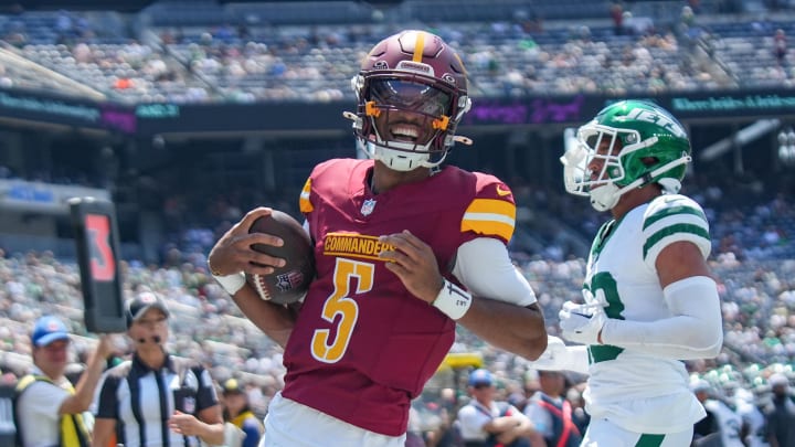 Aug 10, 2024; East Rutherford, New Jersey, USA; Washington Commanders quarterback Jayden Daniels (5) rushes for a touchdown during the first quarter against the New York Jets at MetLife Stadium. Mandatory Credit: Lucas Boland-USA TODAY Sports