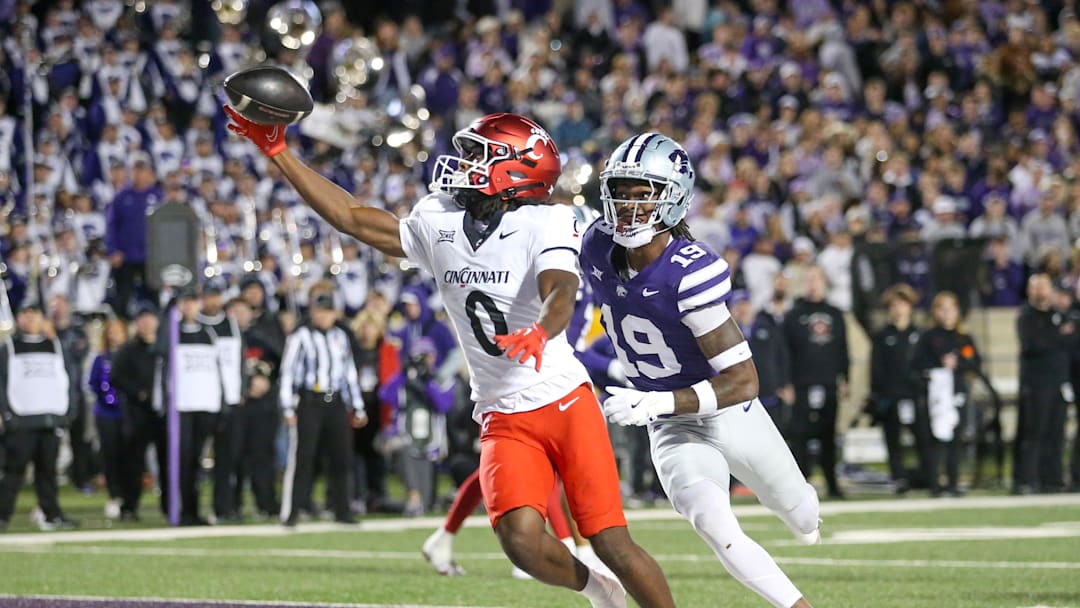 Nov 23, 2024; Manhattan, Kansas, USA; Cincinnati Bearcats wide receiver Tony Johnson (0) makes a touchdown catch against Kansas State Wildcats safety VJ Payne (19) during the third quarter at Bill Snyder Family Football Stadium. Mandatory Credit: Scott Sewell-Imagn Images