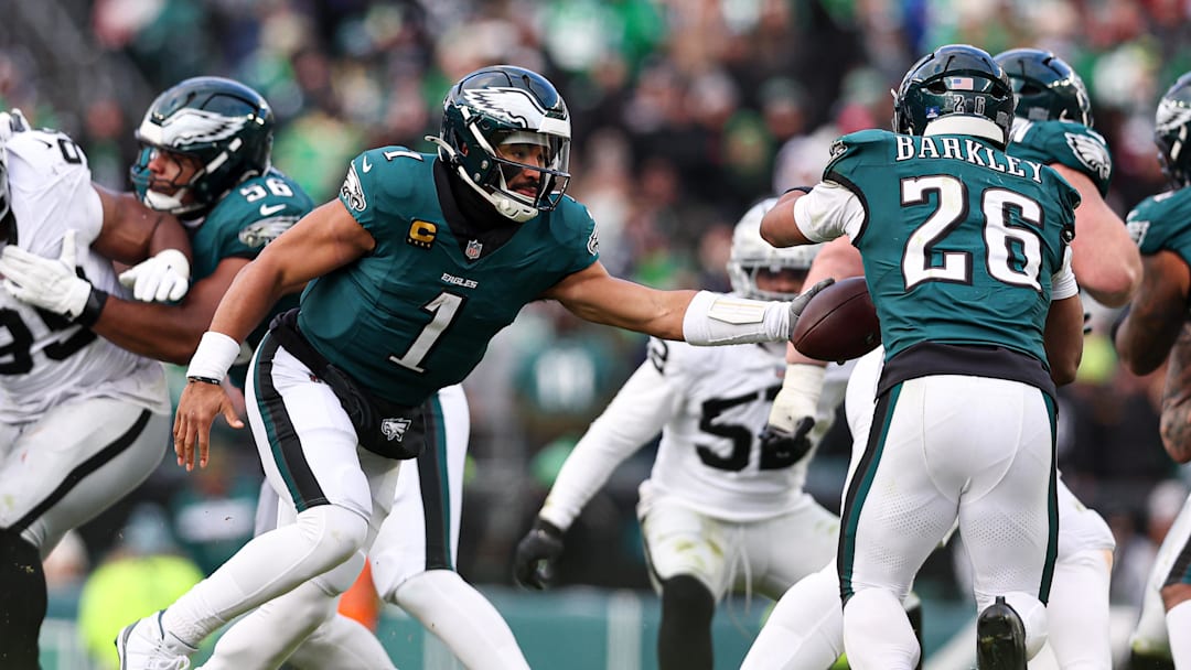 Dec 14, 2025; Philadelphia, Pennsylvania, USA; Philadelphia Eagles quarterback Jalen Hurts (1) hands off to running back Saquon Barkley (26) during the third quarter against the Las Vegas Raiders at Lincoln Financial Field. 
