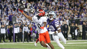 Nov 23, 2024; Manhattan, Kansas, USA; Cincinnati Bearcats wide receiver Tony Johnson (0) makes a touchdown catch against Kansas State Wildcats safety VJ Payne (19) during the third quarter at Bill Snyder Family Football Stadium. Mandatory Credit: Scott Sewell-Imagn Images