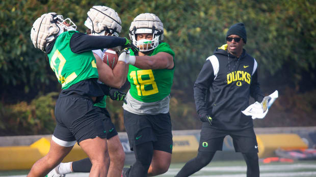 New co-defensive coordinator and safeties coach Chris Hampton, right, joins the first practice of spring for Oregon football