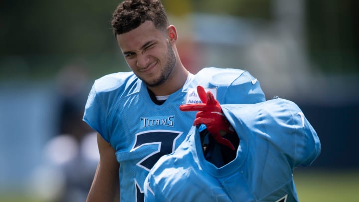 Tennessee Titans cornerback Caleb Farley (3), the Titans first-round draft pick in 2021, carries veteran players' shoulder pads after a training camp practice at Saint Thomas Sports Park.