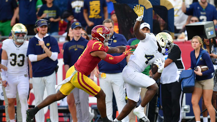 Nov 30, 2024; Los Angeles, California, USA; Notre Dame Fighting Irish running back Jeremiyah Love (4) runs the ball against Southern California Trojans safety Kamari Ramsey (7) during the first half at the Los Angeles Memorial Coliseum. Mandatory Credit: Gary A. Vasquez-Imagn Images Nov 30, 2024; Los Angeles, California, USA; Notre Dame Fighting Irish running back Jeremiyah Love (4) runs the ball against Southern California Trojans safety Kamari Ramsey (7) during the first half at the Los Angeles Memorial Coliseum. Mandatory Credit: Gary A. Vasquez-Imagn Images