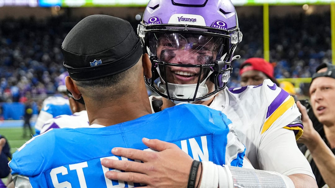 Minnesota Vikings quarterback J.J. McCarthy (9 hugs Detroit Lions wide receiver Amon-Ra St. Brown (14) 