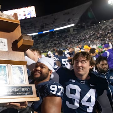 Penn State Nittany Lions football players lift up the Land Grant Trophy after defeating the Michigan State Spartans in 2022. 