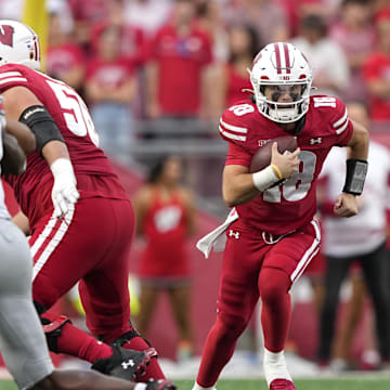 Oct 18, 2025; Madison, Wisconsin, USA; Wisconsin Badgers quarterback Danny O'Neil (18) runs against the Ohio State Buckeyes in the second half at Camp Randall Stadium. Mandatory Credit: Jeff Hanisch-Imagn Images