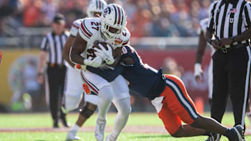 Dec 31, 2024; Orlando, FL, USA; South Carolina Gamecocks running back Oscar Adaway III (27) runs the ball against Illinois Fighting Illini linebacker Jojo Hayden (30) in the first quarter at Camping World Stadium. Mandatory Credit: Jeremy Reper-Imagn Images