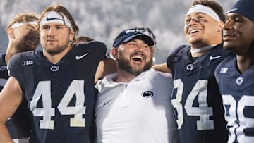 Penn State co-offensive coordinator/tight ends coach Ty Howle (center) puts his arms around tight ends Tyler Warren (44) and Theo Johnson (84)