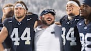 Penn State tight ends coach Ty Howle (center) puts his arms around tight ends Tyler Warren (44) and Theo Johnson (84) following a 31-0 win over Iowa in 2023. 