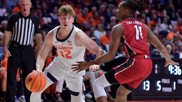 Nov 8, 2024; Champaign, Illinois, USA;  Illinois Fighting Illini guard Kasparas Jakucionis (32) drives against SIU Edwardsville Cougars guard Brian Taylor II (11) during the first half at State Farm Center. Mandatory Credit: Ron Johnson-Imagn Images