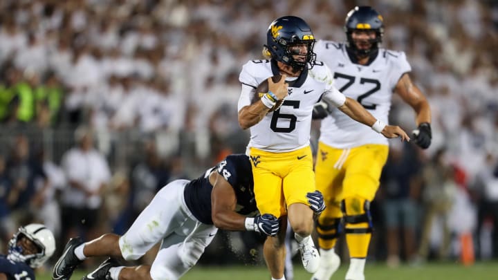 West Virginia quarterback Garrett Greene runs with the ball while trying to avoid a tackle during the third quarter against Penn State at Beaver Stadium in 2023.