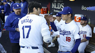 Oct 5, 2024; Los Angeles, California, USA; Los Angeles Dodgers designated hitter Shohei Ohtani (17) and pitcher Yoshinobu Yamamoto (18) interact before playing the San Diego Padres during game one of the NLDS for the 2024 MLB Playoffs at Dodger Stadium. 
