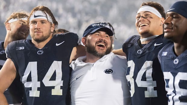 Penn State co-offensive coordinator/tight ends coach Ty Howle (center) puts his arms around tight ends Tyler Warren (44) and 