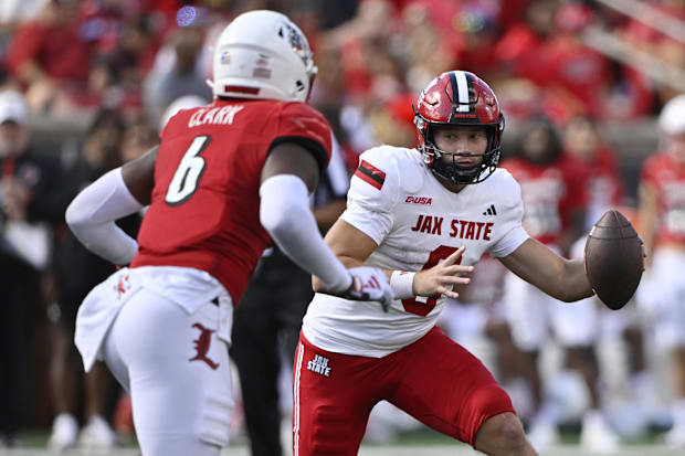 Jacksonville State quarterback Tyler Huff (6) runs the ball against Louisville linebacker Stanquan Clark (6)