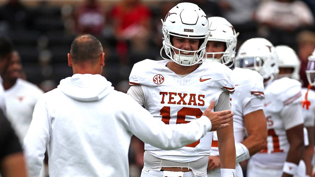 Texas Longhorns quarterback Arch Manning runs the ball with head coach Steve Sarkisian during warm-ups prior to the game against the Mississippi State Bulldogs