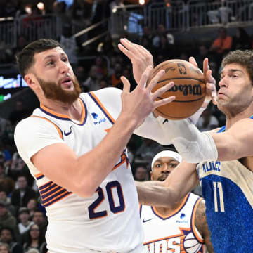 Mar 17, 2024; Milwaukee, Wisconsin, USA; Phoenix Suns center Jusuf Nurkic (20) and Milwaukee Bucks center Brook Lopez (11) battle for possession of the ball in the first half at Fiserv Forum. Mandatory Credit: Michael McLoone-USA TODAY Sports