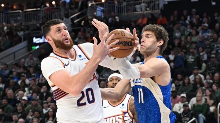 Mar 17, 2024; Milwaukee, Wisconsin, USA; Phoenix Suns center Jusuf Nurkic (20) and Milwaukee Bucks center Brook Lopez (11) battle for possession of the ball in the first half at Fiserv Forum. Mandatory Credit: Michael McLoone-USA TODAY Sports