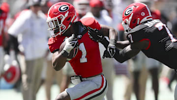 Georgia Bulldogs running back Trevor Etienne (1) gets tackled by defensive back Daniel Harris (7) 