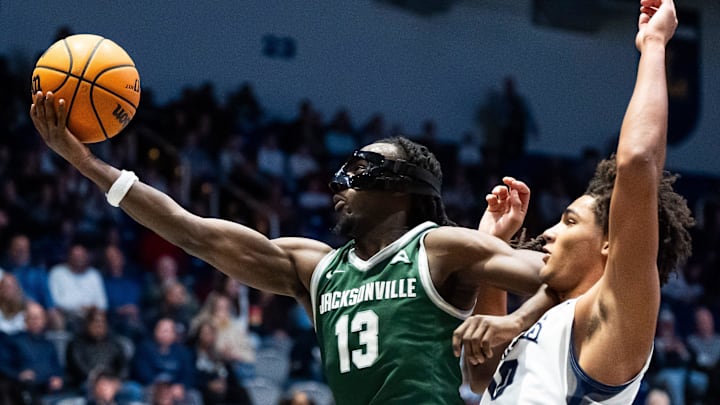 Jacksonville Dolphins guard Robert McCray V (13) grabs a rebound away from North Florida Ospreys forward Josh Harris (10) in the first half. Jacksonville University played University of North Florida Thursday night, February 20, 2025 in the River City Rumble in Jacksonville, Fl. JU lead 35-34 over UNF at the half. [Doug Engle/Florida Times-Union]2025