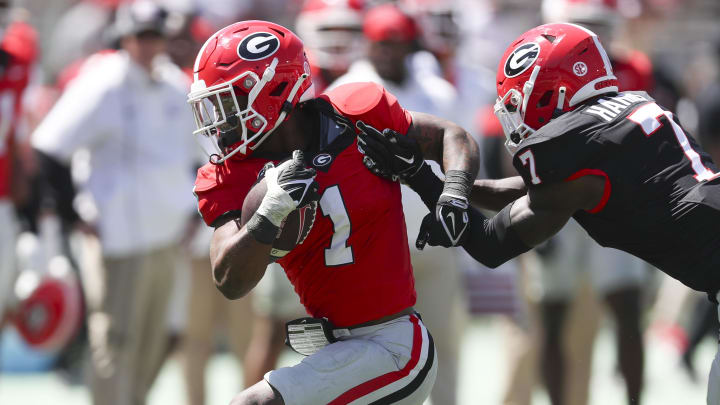 Apr 13, 2024; Athens, GA, USA; Georgia Bulldogs running back Trevor Etienne (1) gets tackled by defensive back Daniel Harris (7) during the G-Day Game at Sanford Stadium. Mandatory Credit: Mady Mertens-USA TODAY Sports