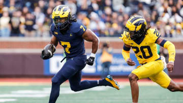 Blue Team running back Donovan Edwards (7) runs against Maize Team defensive back Jyaire Hill (20) during the first half of the spring game at Michigan Stadium in Ann Arbor on Saturday, April 20, 2024.
