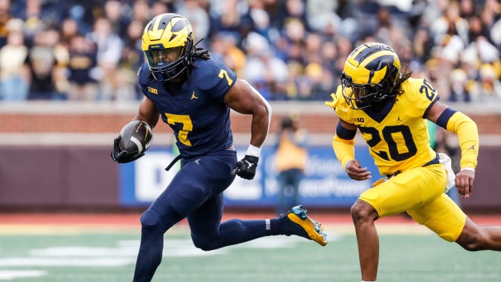 Blue Team running back Donovan Edwards (7) runs against Maize Team defensive back Jyaire Hill (20) during the first half of the spring game at Michigan Stadium in Ann Arbor on Saturday, April 20, 2024.