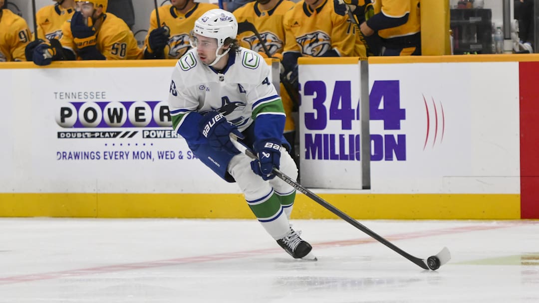 Oct 23, 2025; Nashville, Tennessee, USA;  Vancouver Canucks defenseman Quinn Hughes (43) skates with the puck against the Nashville Predators during the first period at Bridgestone Arena. Mandatory Credit: Steve Roberts-Imagn Images