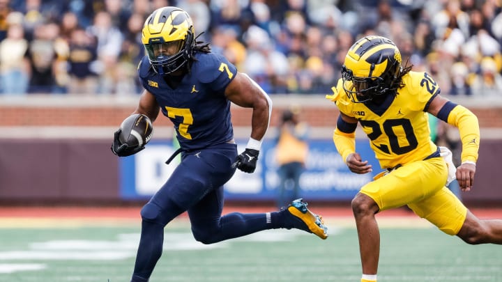 Blue Team running back Donovan Edwards (7) runs against Maize Team defensive back Jyaire Hill (20) during the first half of the spring game at Michigan Stadium in Ann Arbor on Saturday, April 20, 2024.