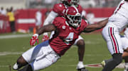 Oct 12, 2024; Tuscaloosa, Alabama, USA;  Alabama Crimson Tide linebacker Qua Russaw (4) tries to bring down South Carolina Gamecocks quarterback Robby Ashford (1) at Bryant-Denny Stadium. Mandatory Credit: Gary Cosby Jr.-Imagn Images