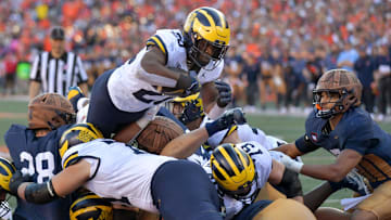 Oct 19, 2024; Champaign, Illinois, USA;  Michigan Wolverines running back Kalel Mullings (20) leaps over the line to score a touchdown against the Illinois Fighting Illini during the first half at Memorial Stadium. Mandatory Credit: Ron Johnson-Imagn Images