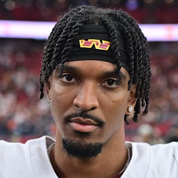 Sep 29, 2024; Glendale, Arizona, USA;  Washington Commanders quarterback Jayden Daniels (5) looks on after beating the Arizona Cardinals at State Farm Stadium. Mandatory Credit: Matt Kartozian-Imagn Images