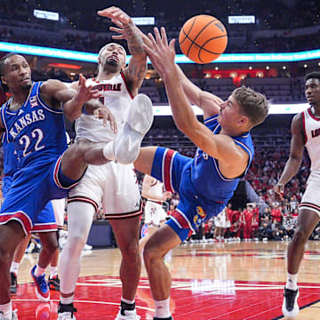 Kansas Jayhawks guard Darryn Peterson (22) and Kansas Jayhawks guard Kohl Rosario (7) surround Louisville Cardinals guard J'Vonne Hadley (1) as the trio battle for a loose ball during an exhibition game at the KFC Yum! Center in Louisville, Kentucky Friday, October 24, 2025.