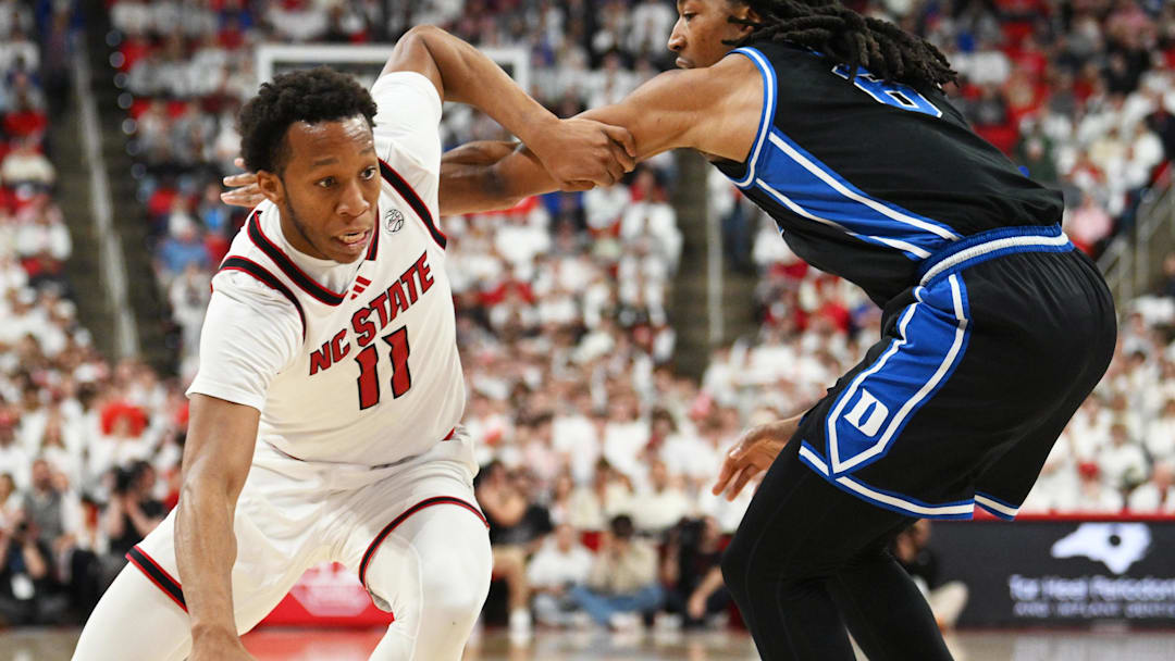 Mar 2, 2026; Raleigh, North Carolina, USA;  NC State Wolfpack guard Quadir Copeland (11) drives the ball around Duke Blue Devils forward Maliq Brown (6) during the first half at Lenovo Center. Mandatory Credit: Zachary Taft-Imagn Images