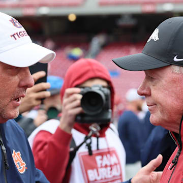 Auburn Tigers coach Hugh Freeze shakes hands with Arkansas Razorbacks interim coach Bobby Petrino after the game at Razorback Stadium. Auburn won 33-24.
