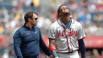 May 26, 2024; Pittsburgh, Pennsylvania, USA;  Atlanta Braves right fielder Ronald Acuña Jr. (13) reacts as he  leaves the field assisted by a Braves trainer after Acuña suffered an apparent injury on a steal attempt against the Pittsburgh Pirates during the first inning at PNC Park. Mandatory Credit: Charles LeClaire-Imagn Images